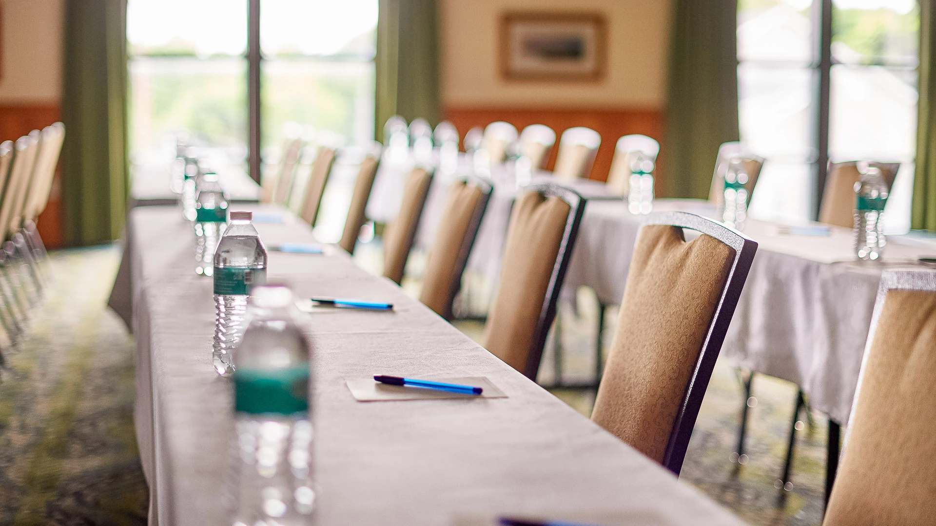 a long table with chairs and a few water bottles