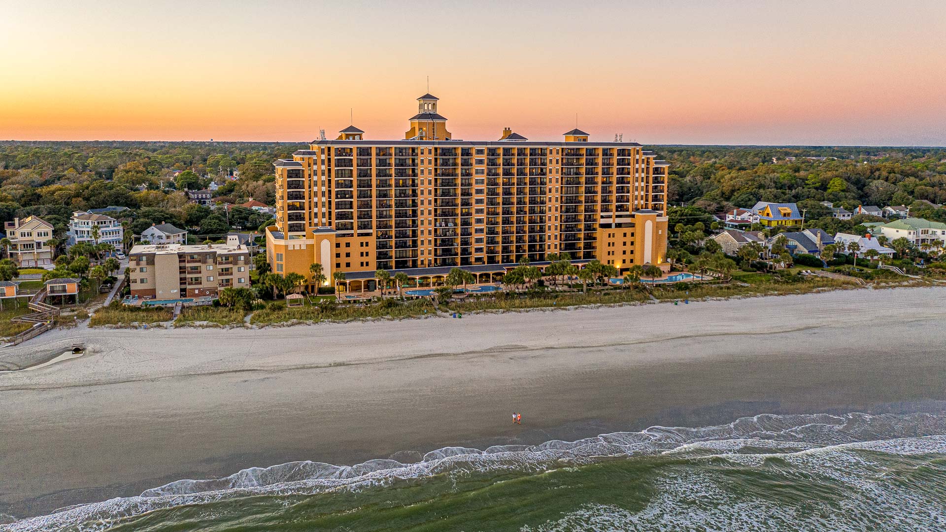 a large building with many windows and a beach