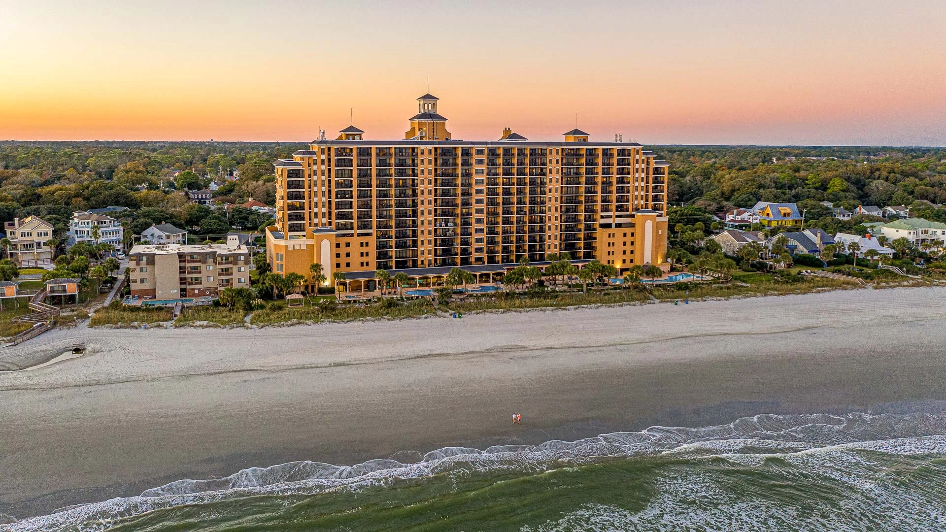 a large building with many windows and a beach