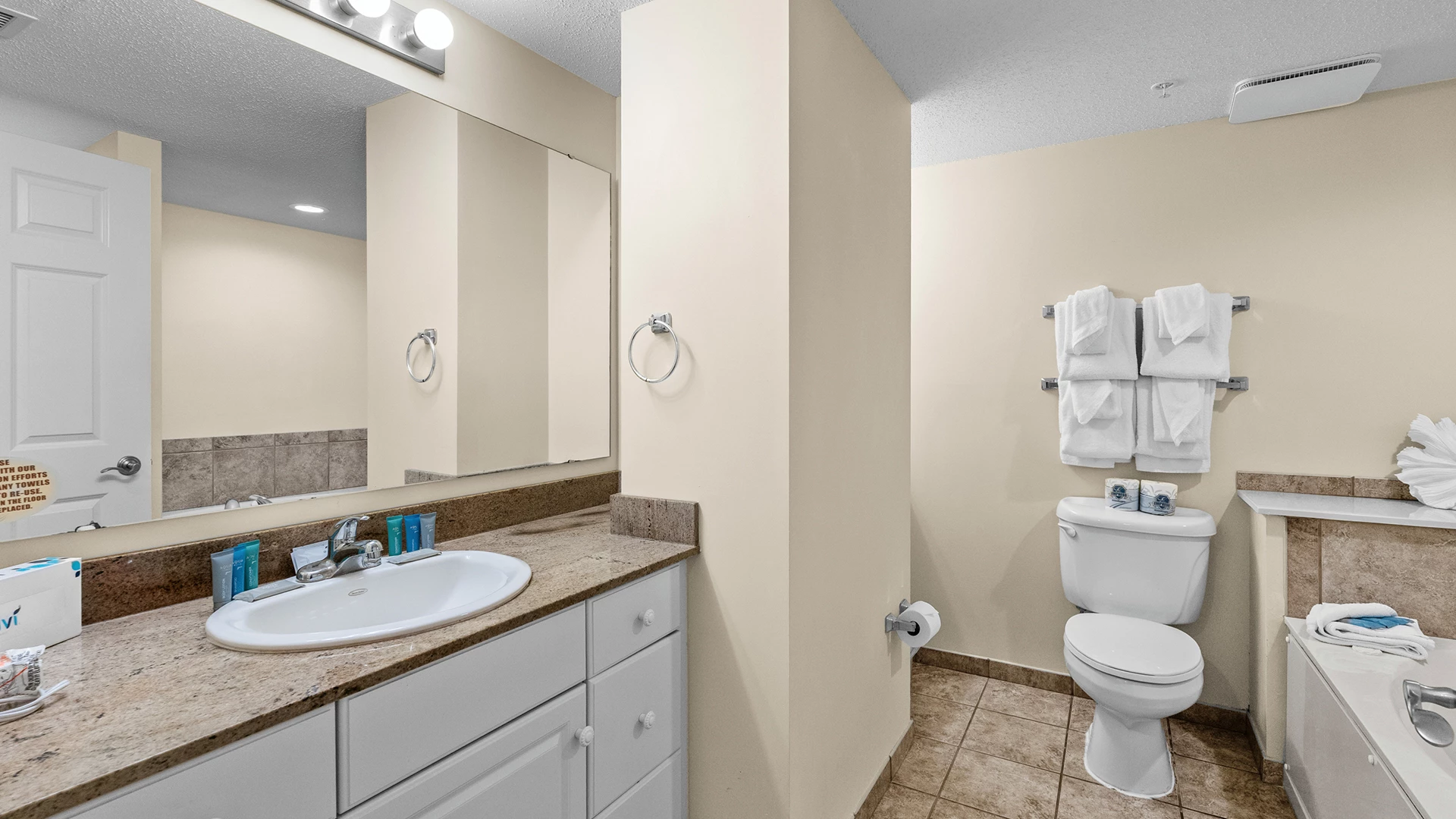A clean bathroom with a sink, toilet, and towels.