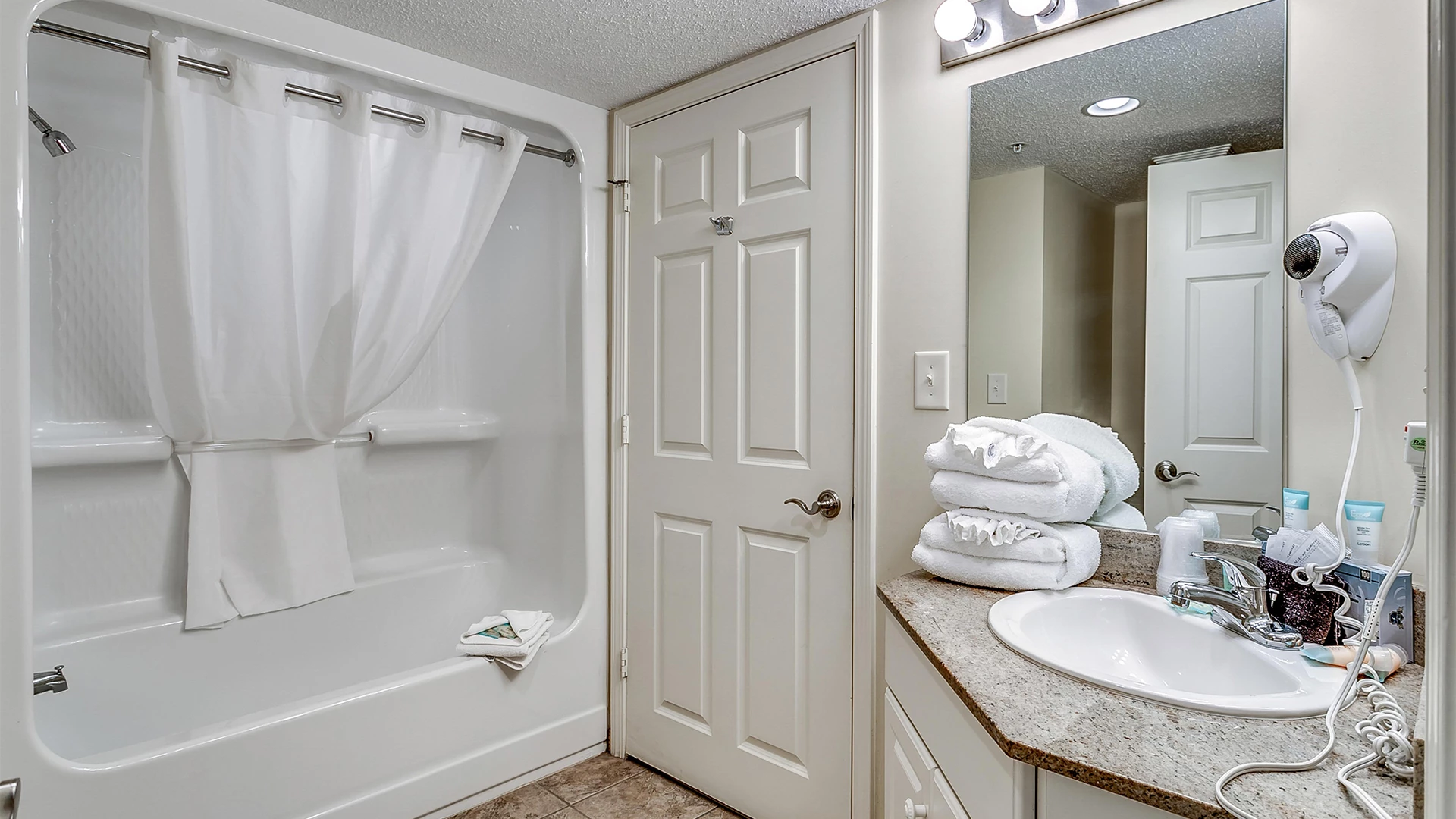 A bathroom with a bathtub, sink, and towels