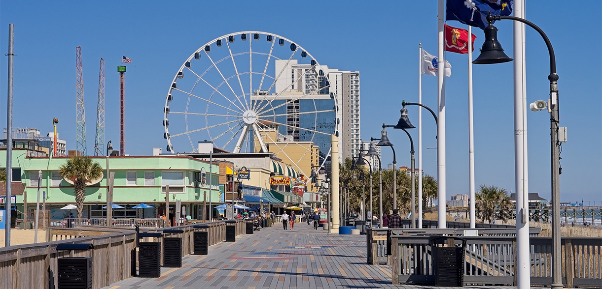 a city street with buildings and a ferris wheel