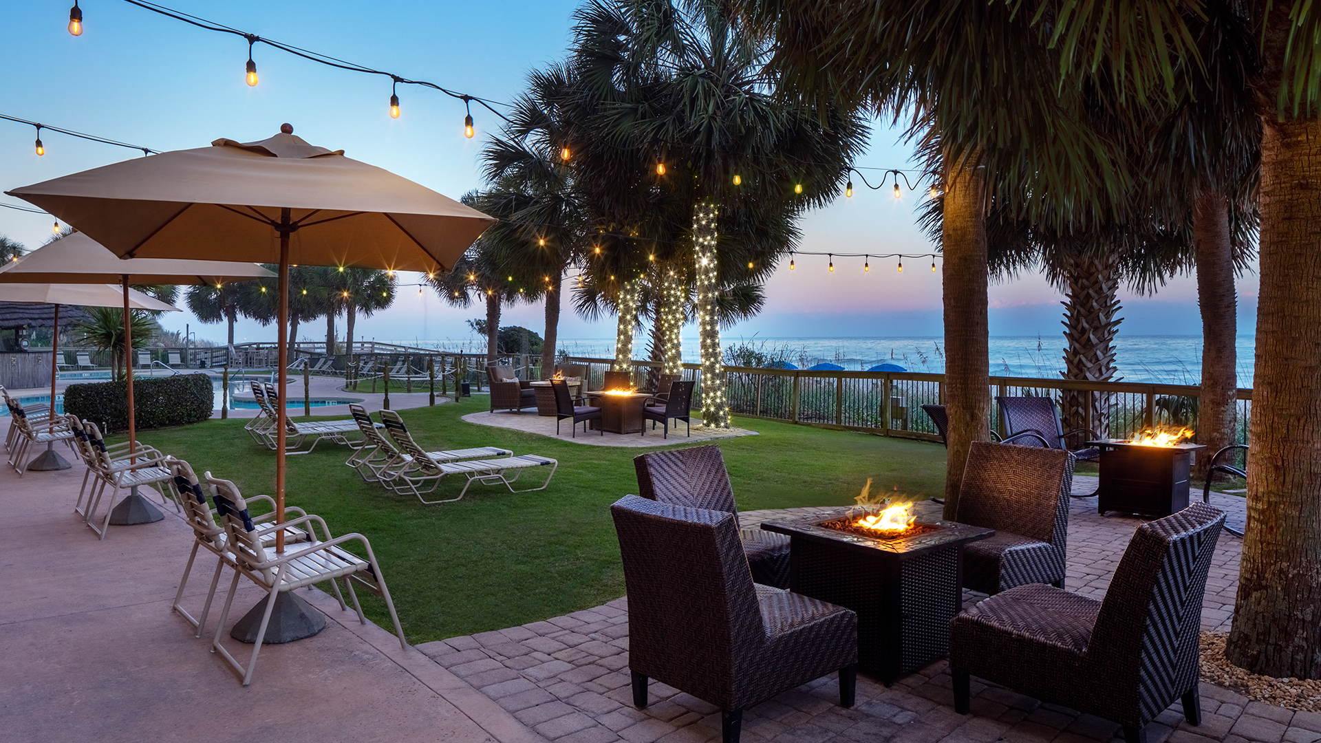 a patio with chairs and a fire pit