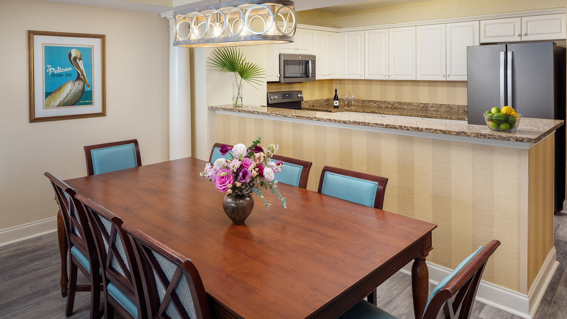 a dining table with chairs and a vase of flowers
