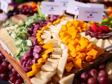 a tray of cheeses and grapes