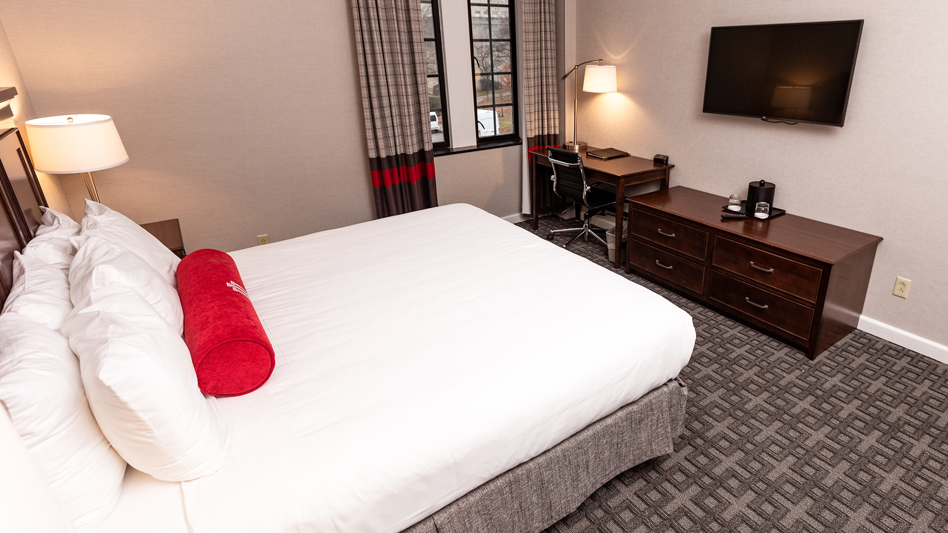 a bed with a red roll on it