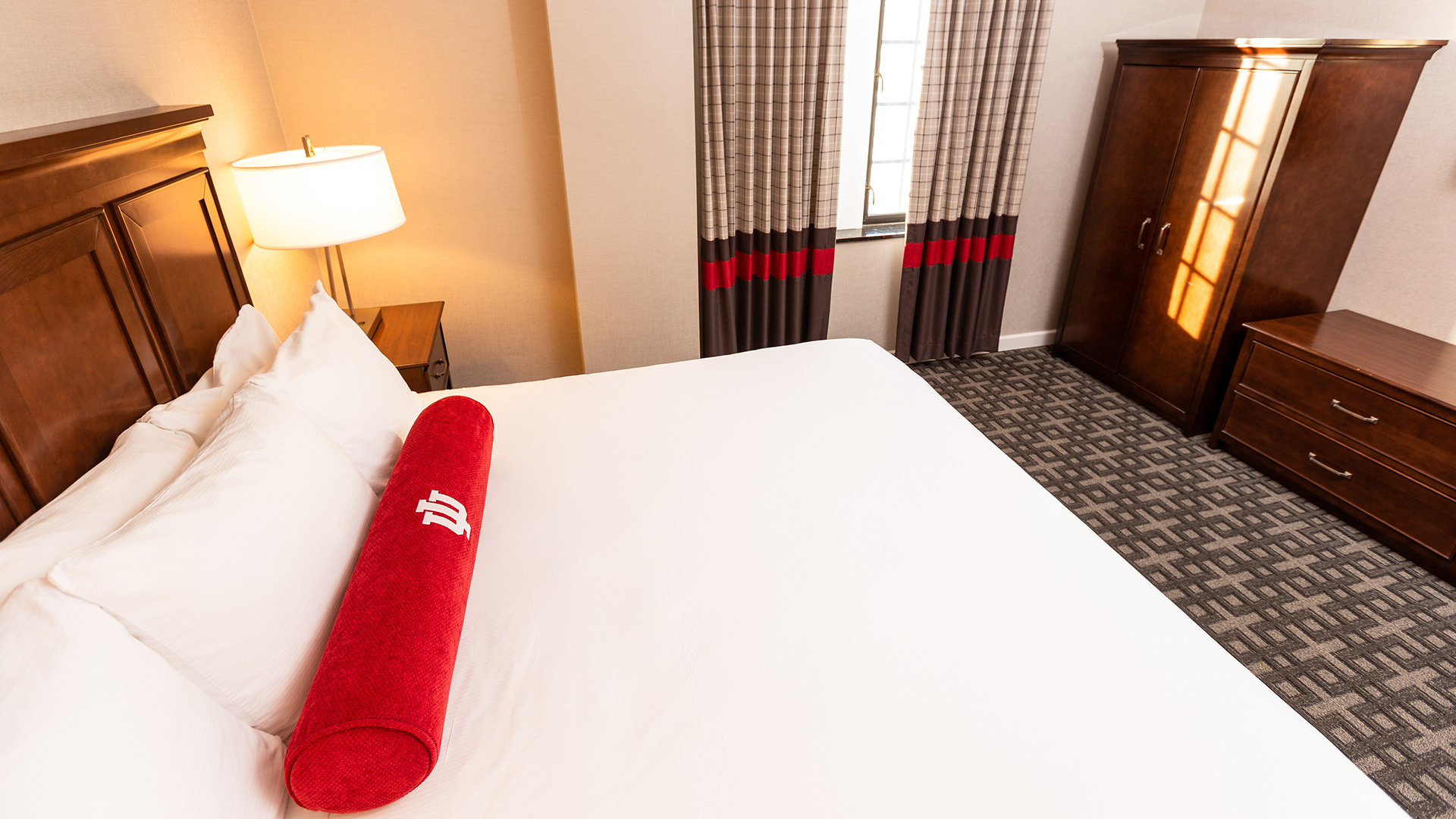 a red rolled up towel on a bed