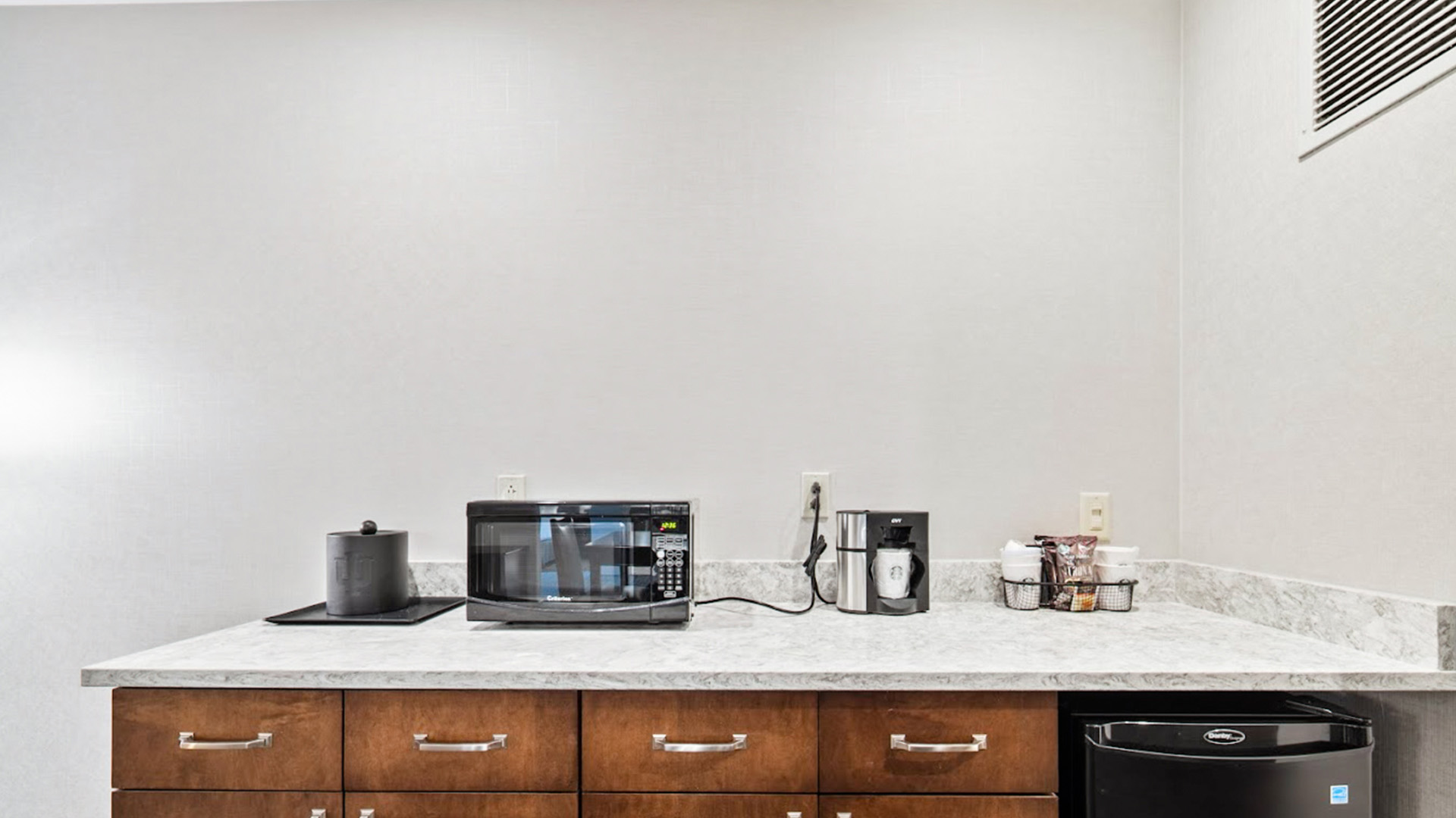 a kitchen counter with a microwave and coffee maker