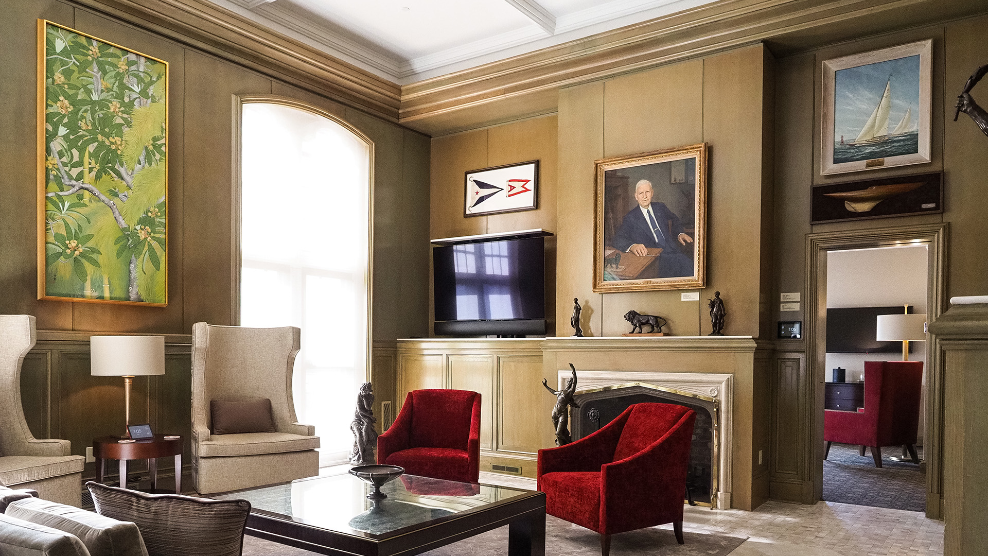 a living room with a fireplace and red chairs