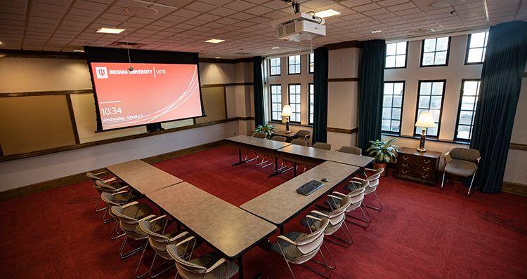 a room with a large screen and tables