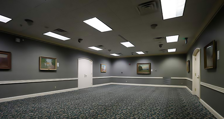 a room with a door and paintings on the wall