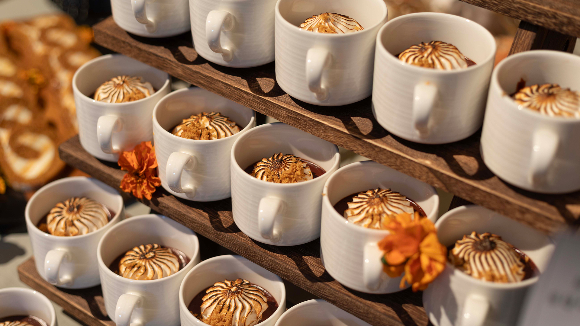 a group of white mugs with desserts on a shelf