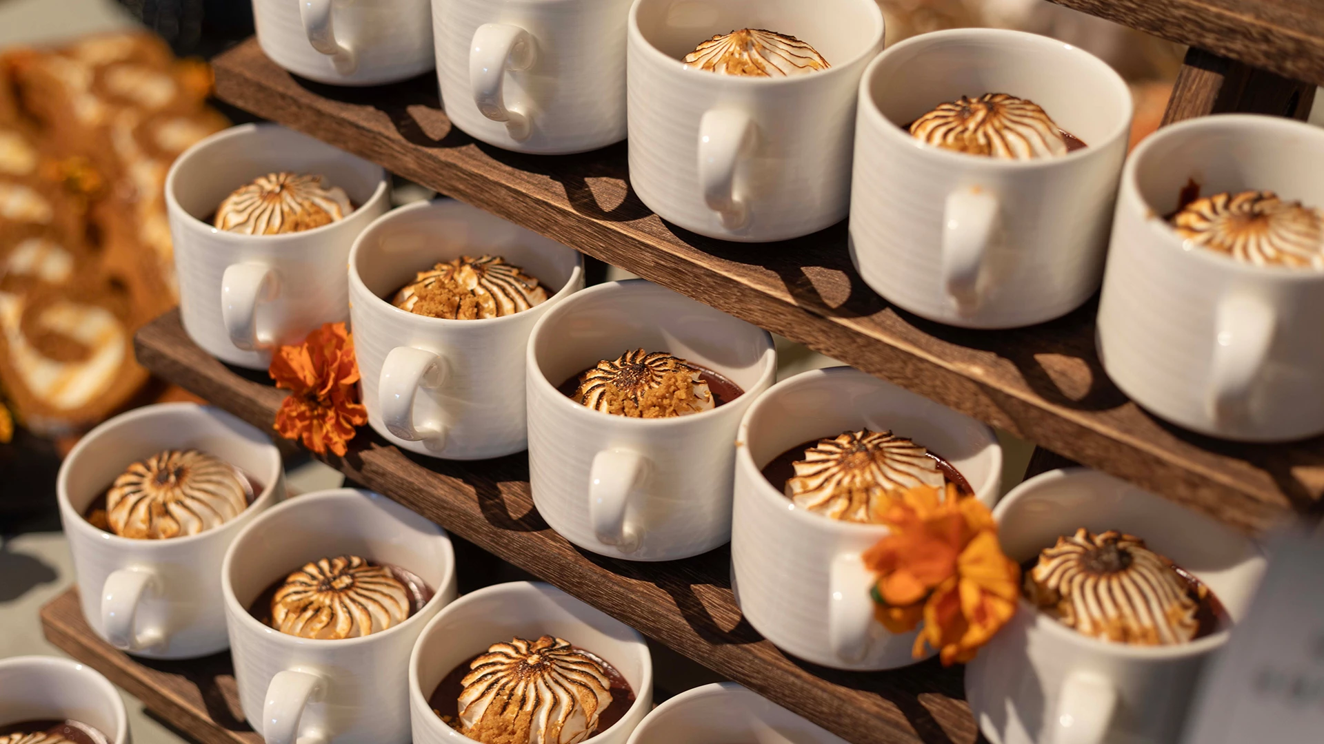 a group of white mugs with desserts on a shelf