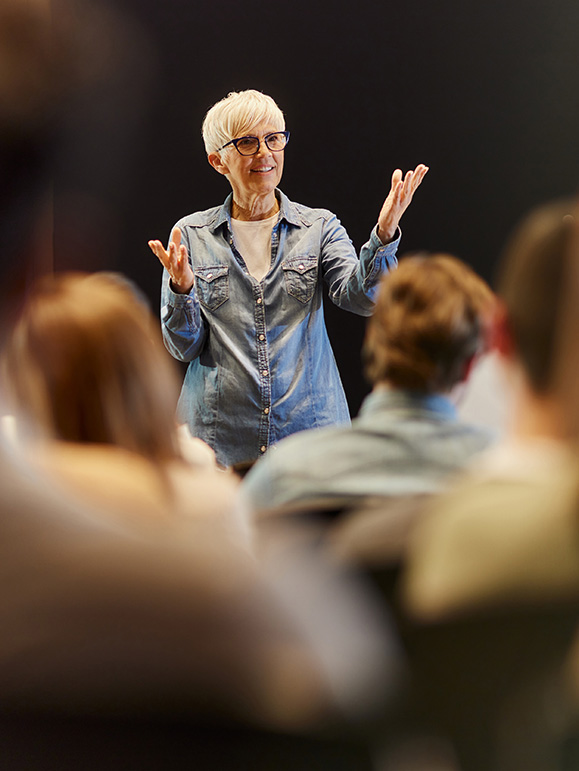 a woman standing in front of a group of people