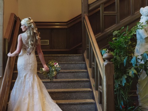a woman in a wedding dress walking up stairs