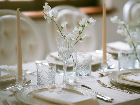 a table set with white flowers and candles