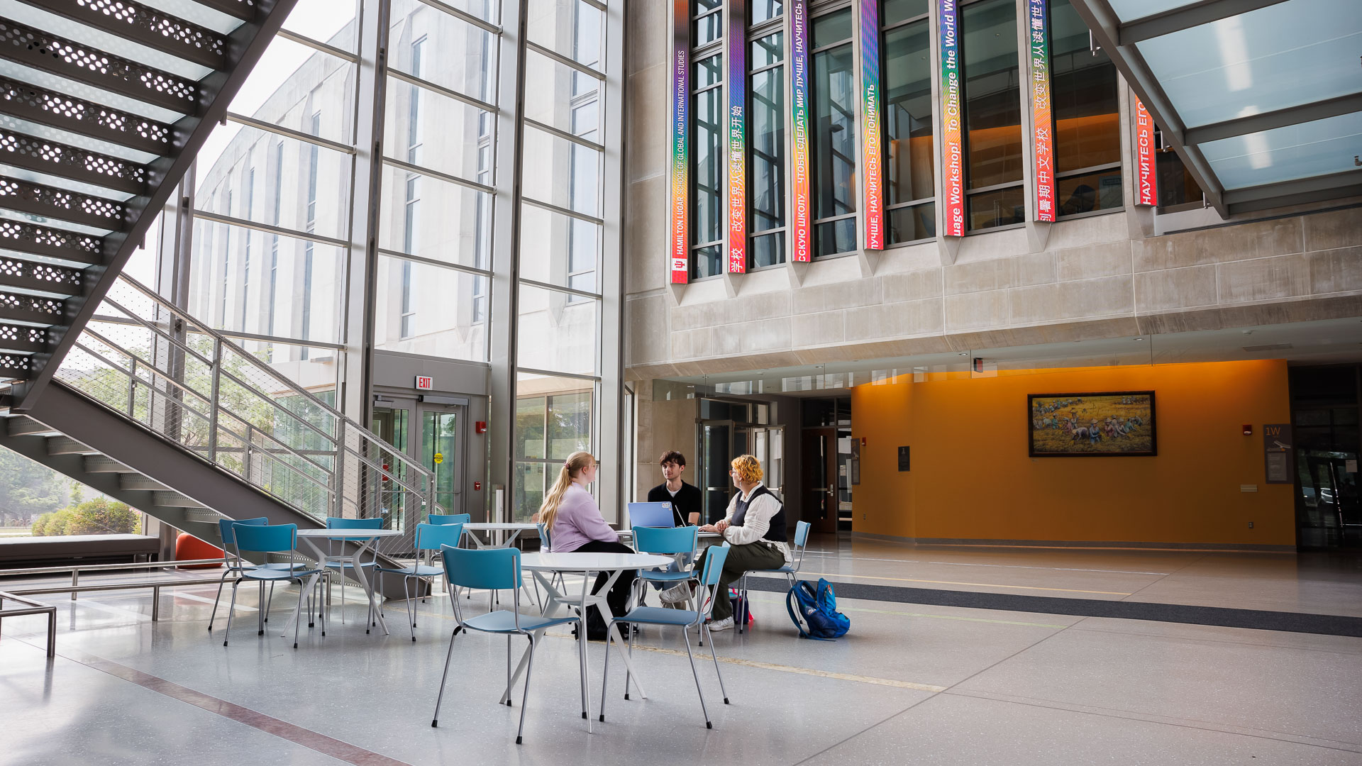 a group of people sitting at tables in a library