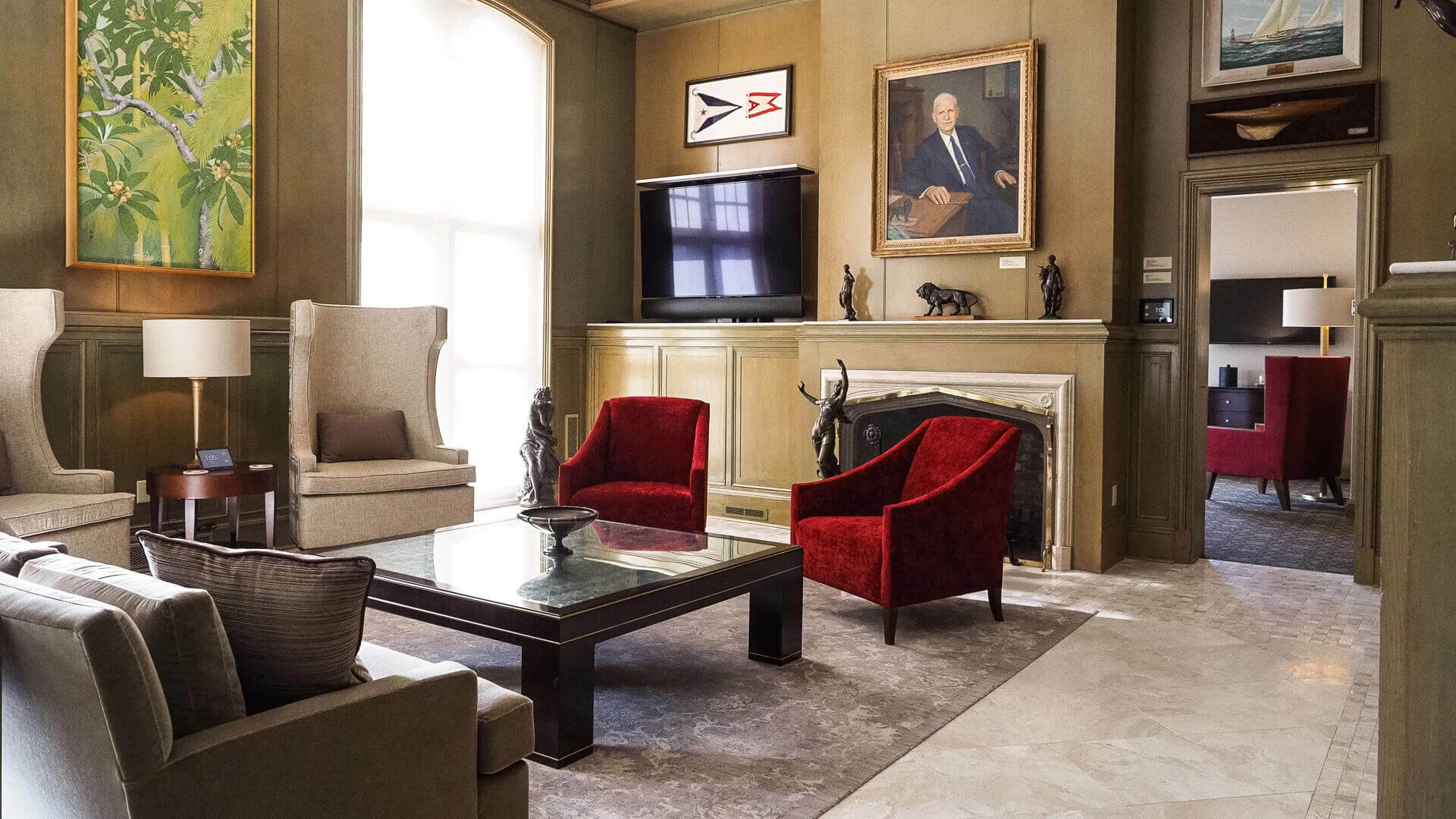 a living room with a fireplace and red chairs