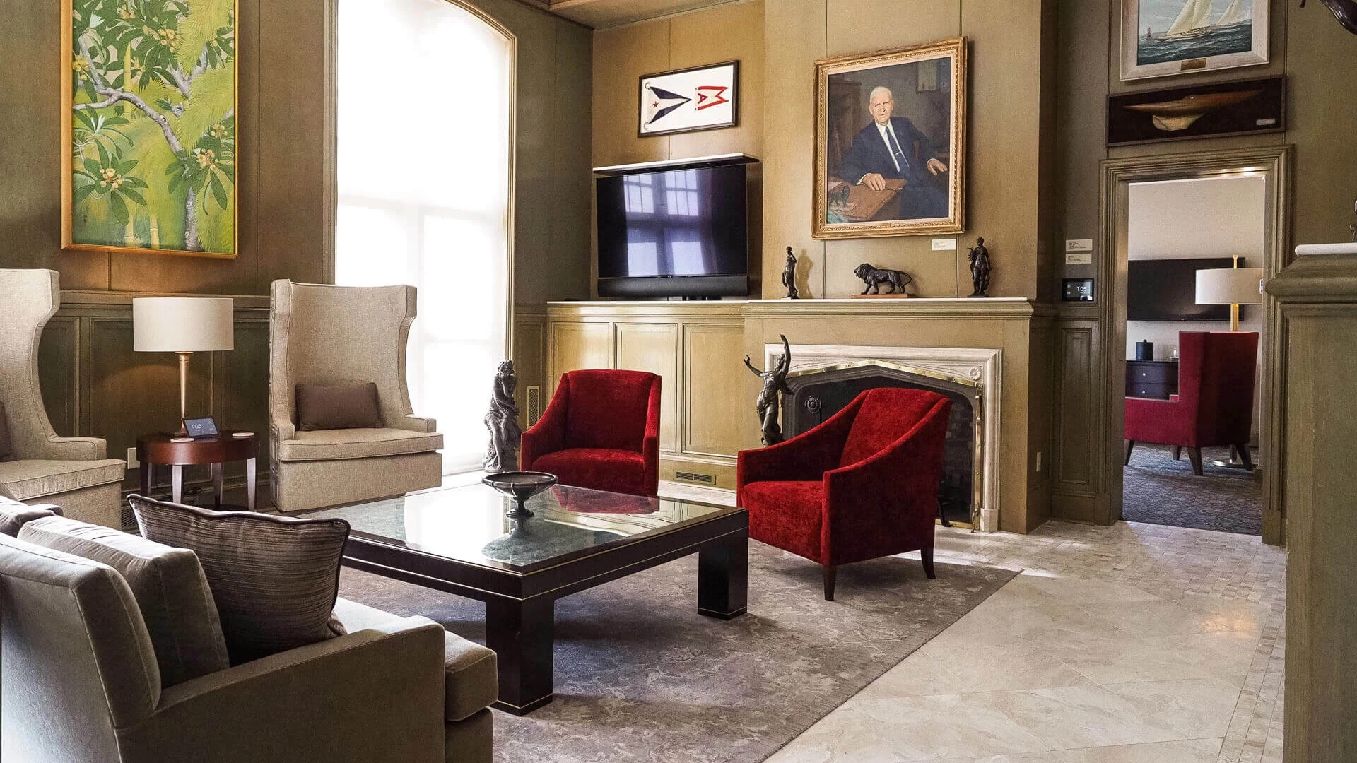 a living room with a fireplace and red chairs