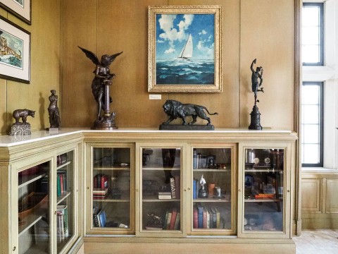 a room with a bookcase and statues