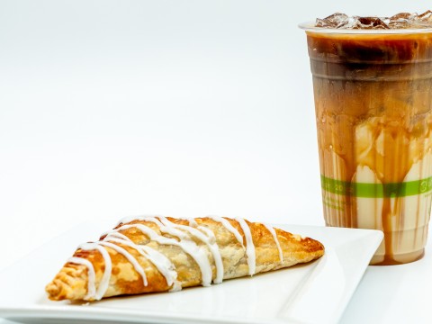 a pastry on a plate next to a drink