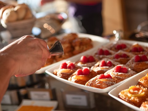 a hand holding a tray of pastries