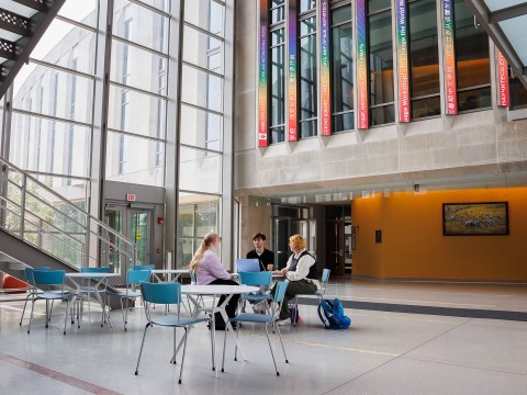 a group of people sitting at tables in a library