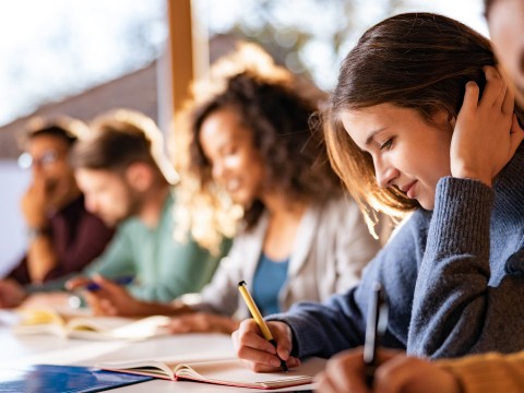 a group of people writing on a table