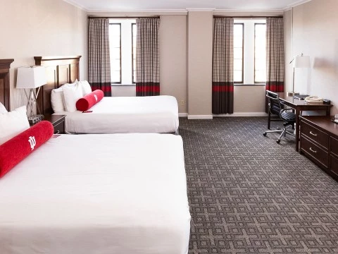 a room with two beds and a desk