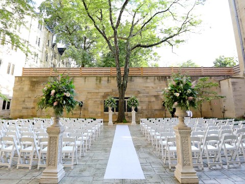 a wedding ceremony with white chairs and flowers