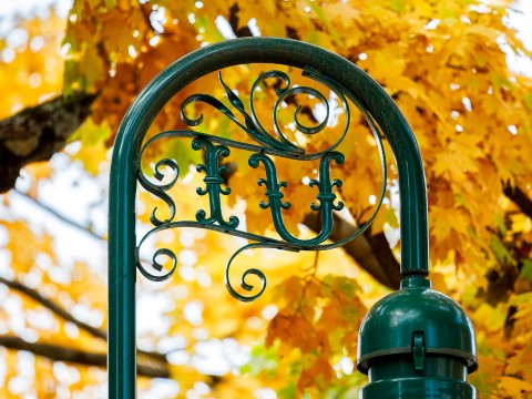 a green metal post with a decorative design