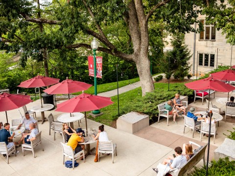 a group of people sitting at tables and umbrellas