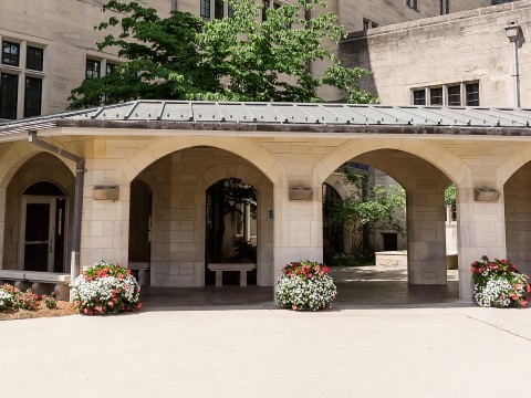 a stone building with a stone structure with a roof and flowers