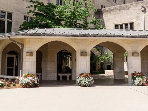 a stone building with a stone structure with a roof and flowers