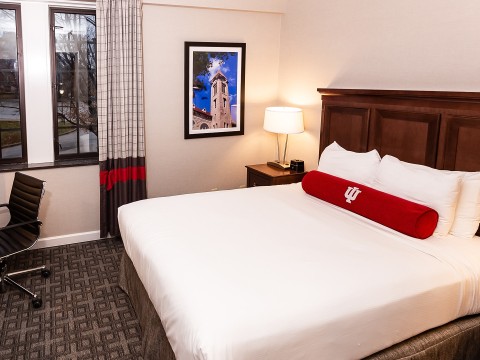 a bed with a red pillow on it