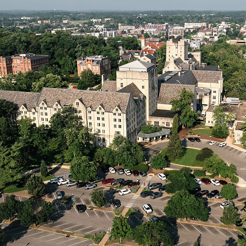 a large building with trees and a parking lot