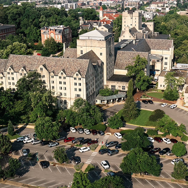 a large building with trees and cars in front of it