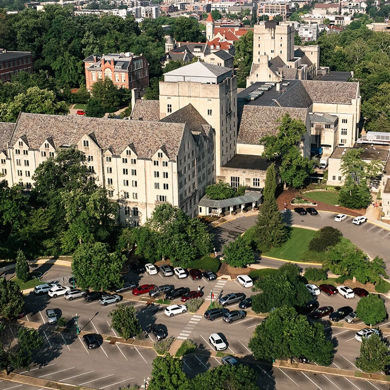 a large building with trees and cars in front of it