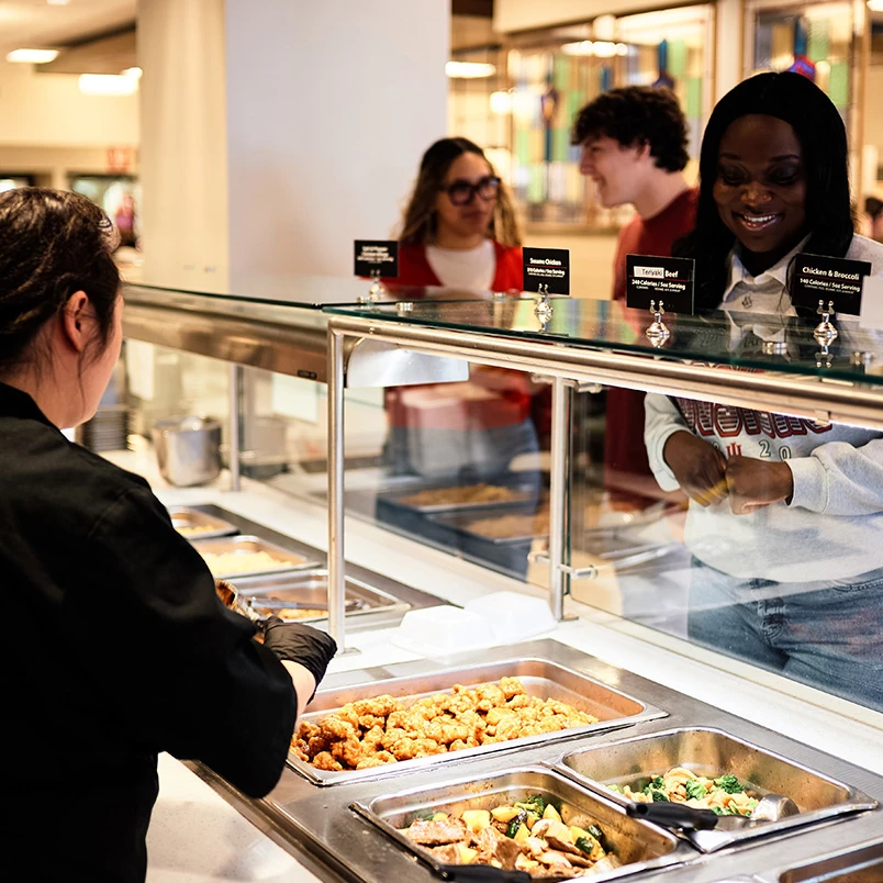 a woman serving food in a buffet