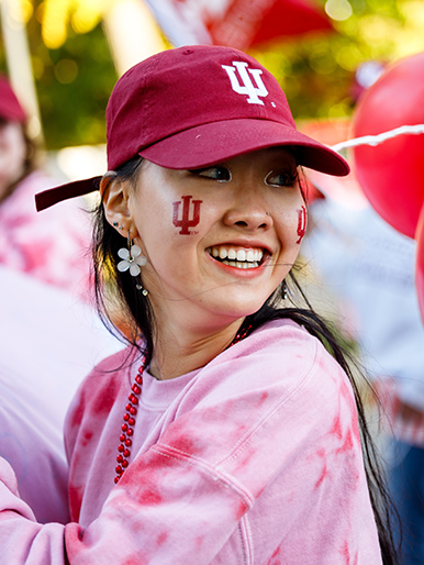 a woman wearing a hat and red shirt with a logo on her face