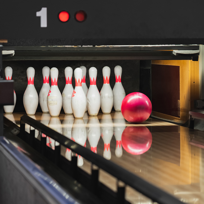 a bowling alley with a ball and pins