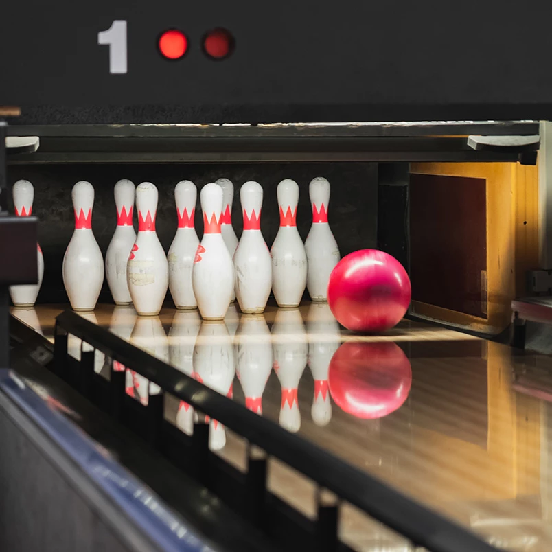 a bowling alley with a ball and pins