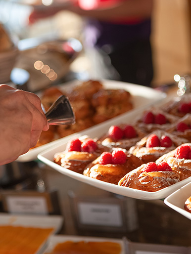 a hand holding a tray of pastries