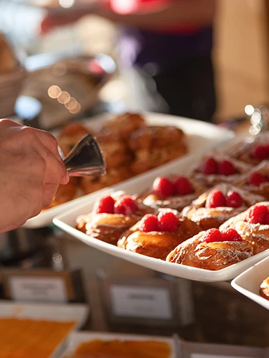 a hand holding a tray of pastries