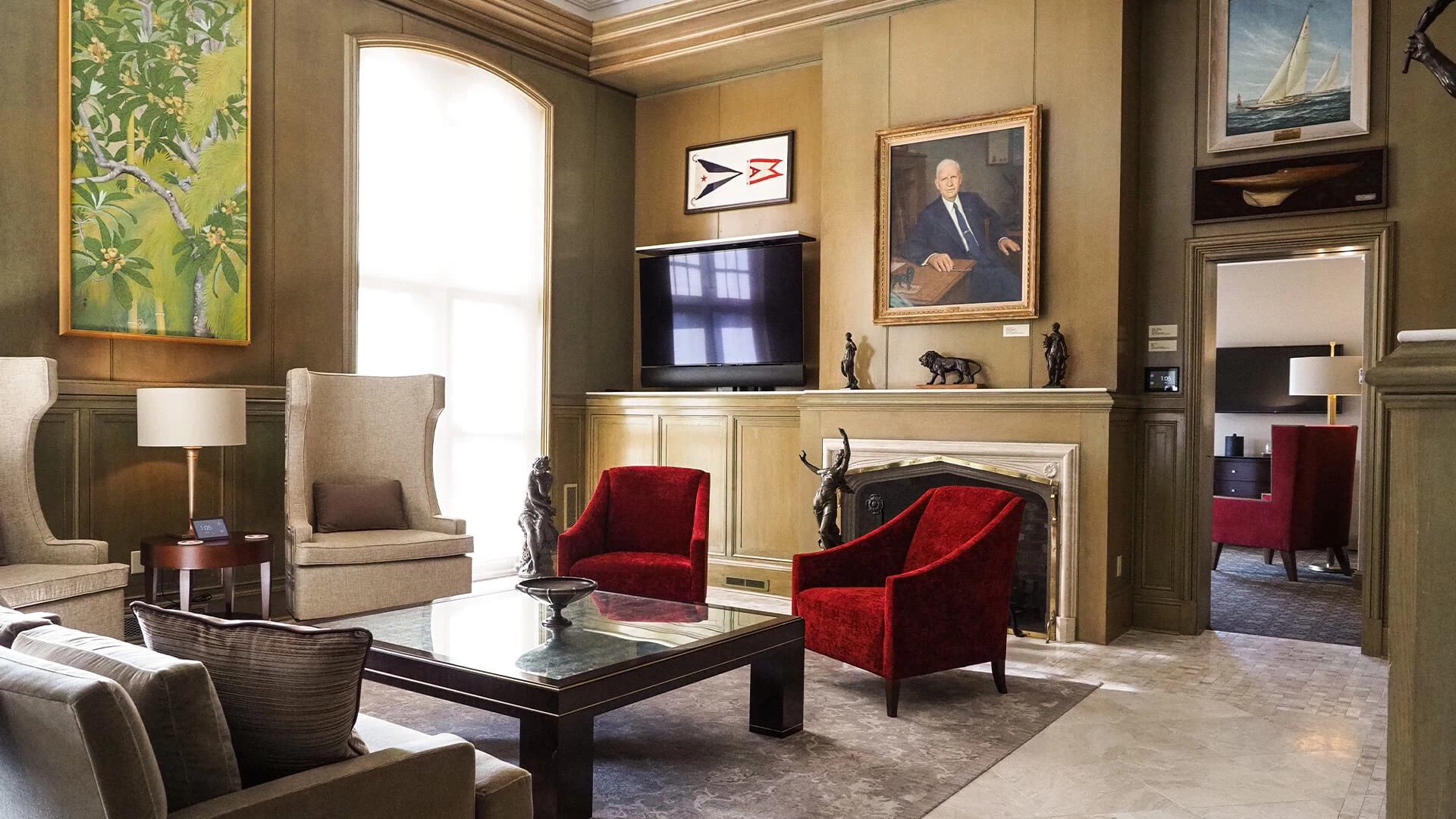 a living room with a fireplace and red chairs