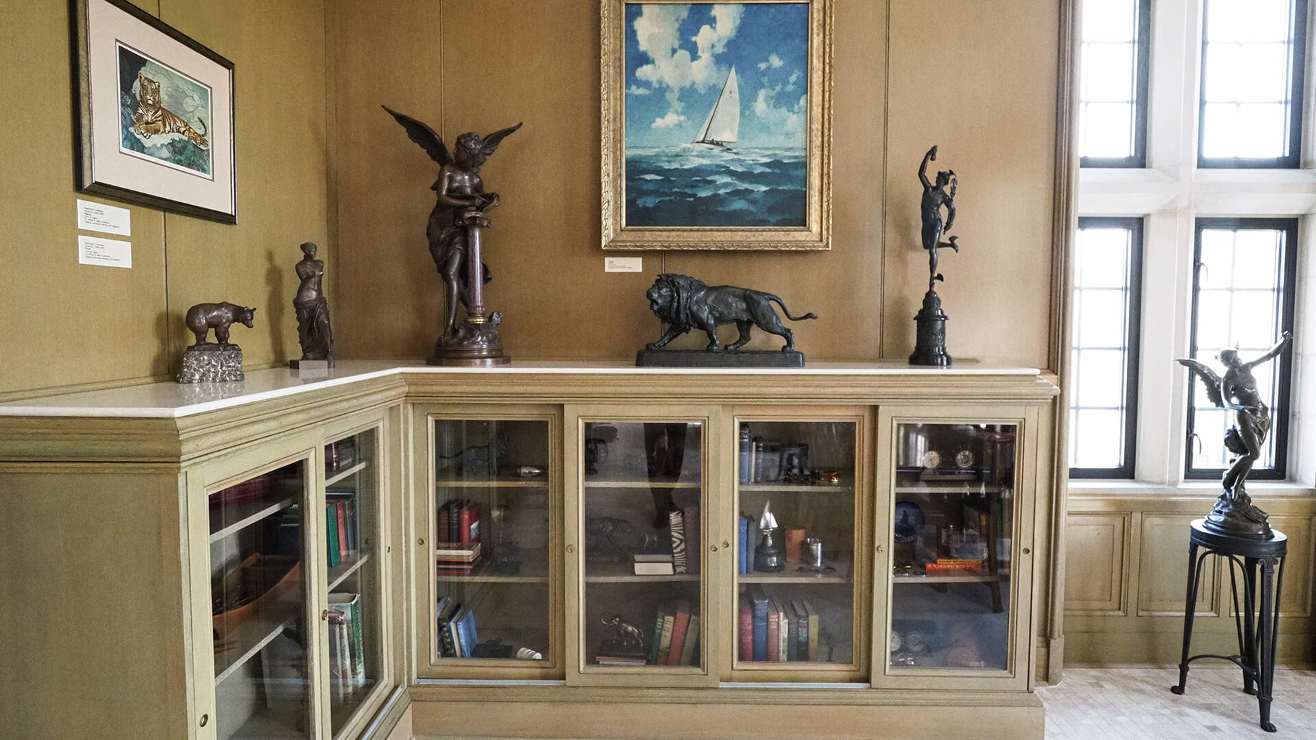 a room with a painting and statues on top of a shelf
