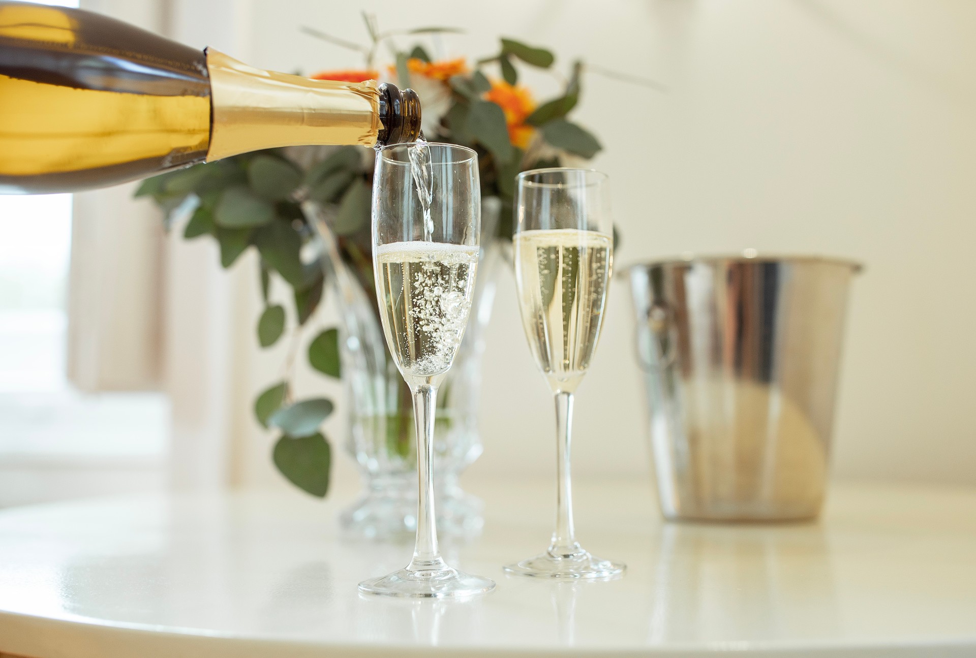 a champagne being poured into two glasses