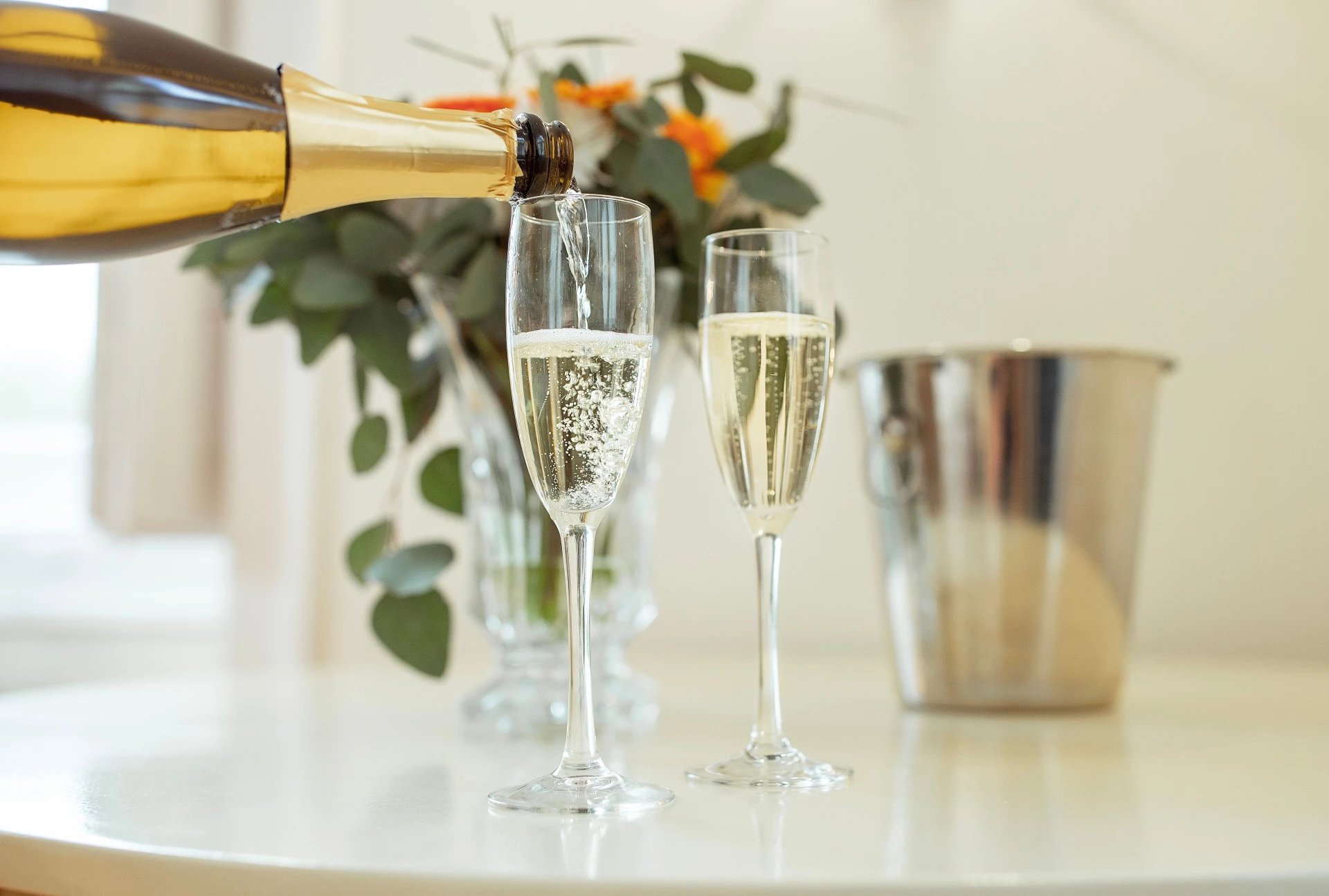 a champagne being poured into two glasses