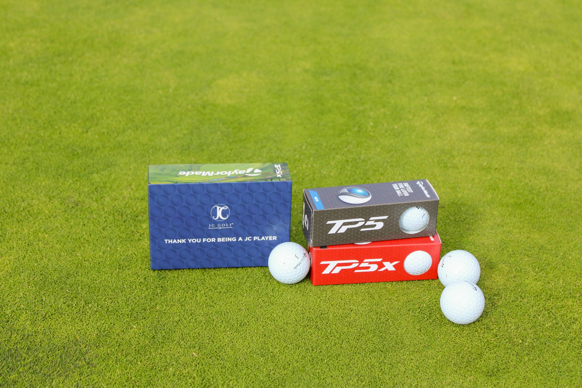 golf balls on boxes on a green surface