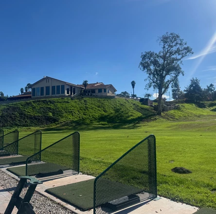 a golf course with a house in the background